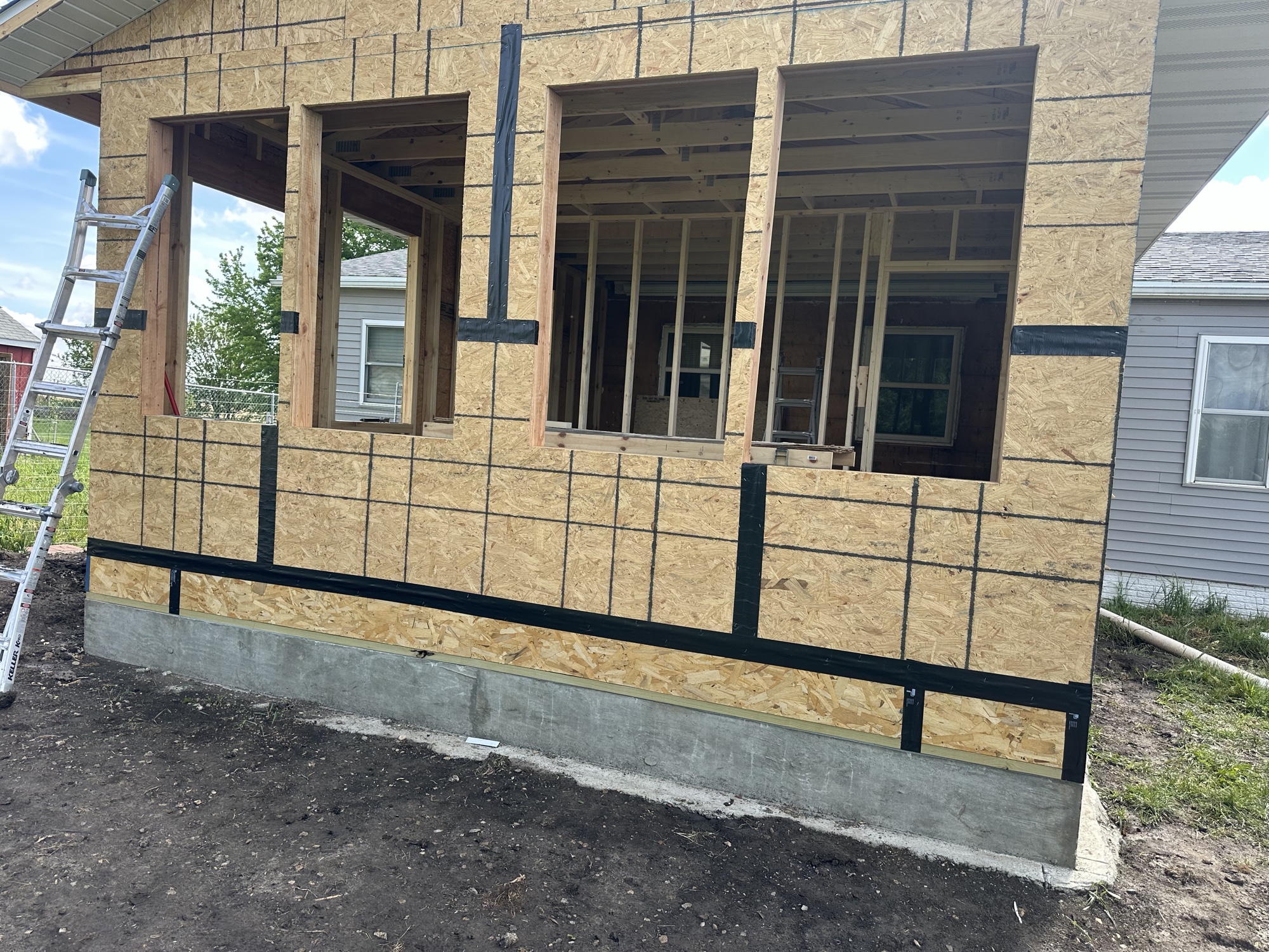 Addition framing with window openings over a new concrete foundation