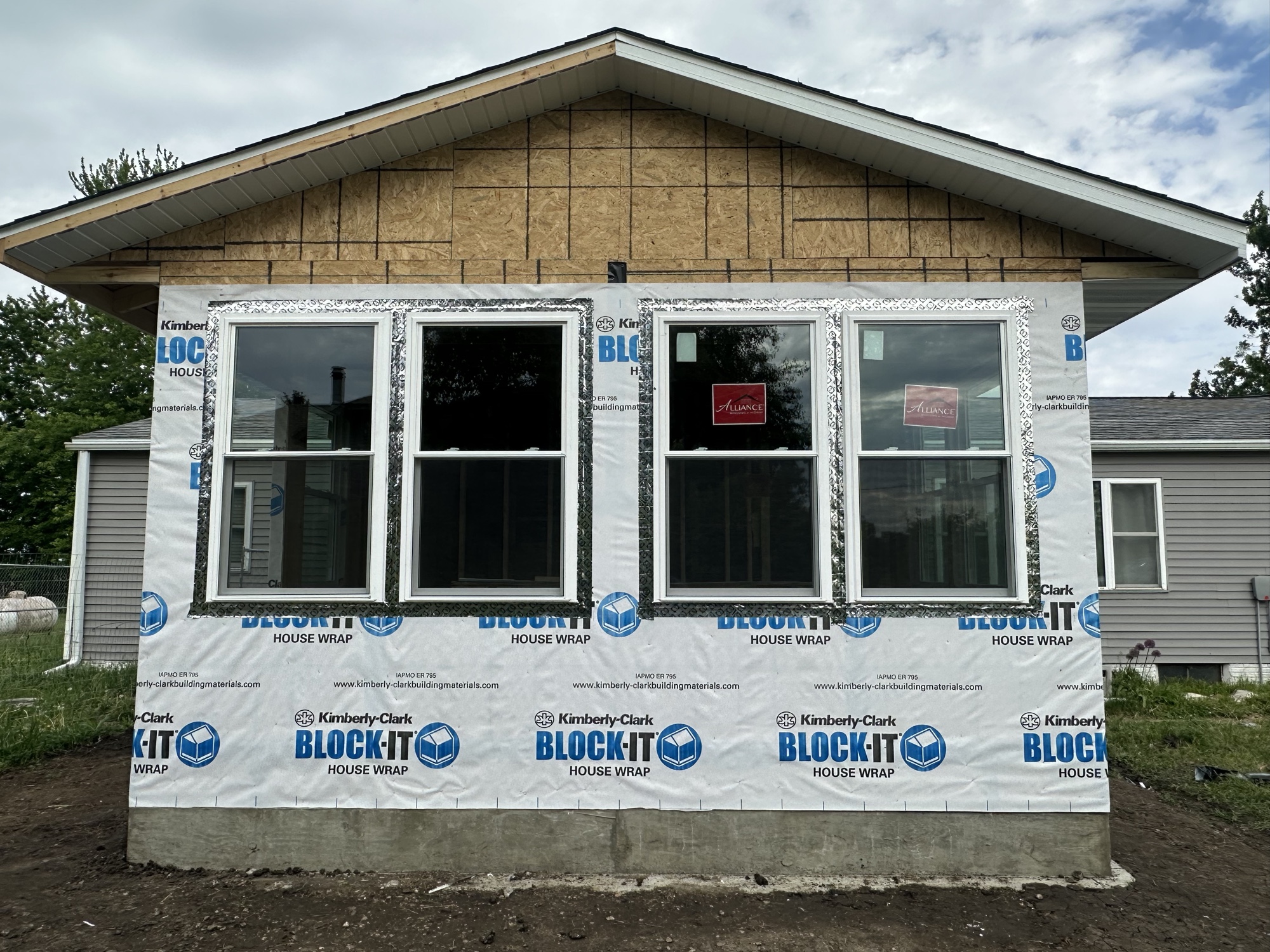 Addition gable wrapped with new double-hung windows installed