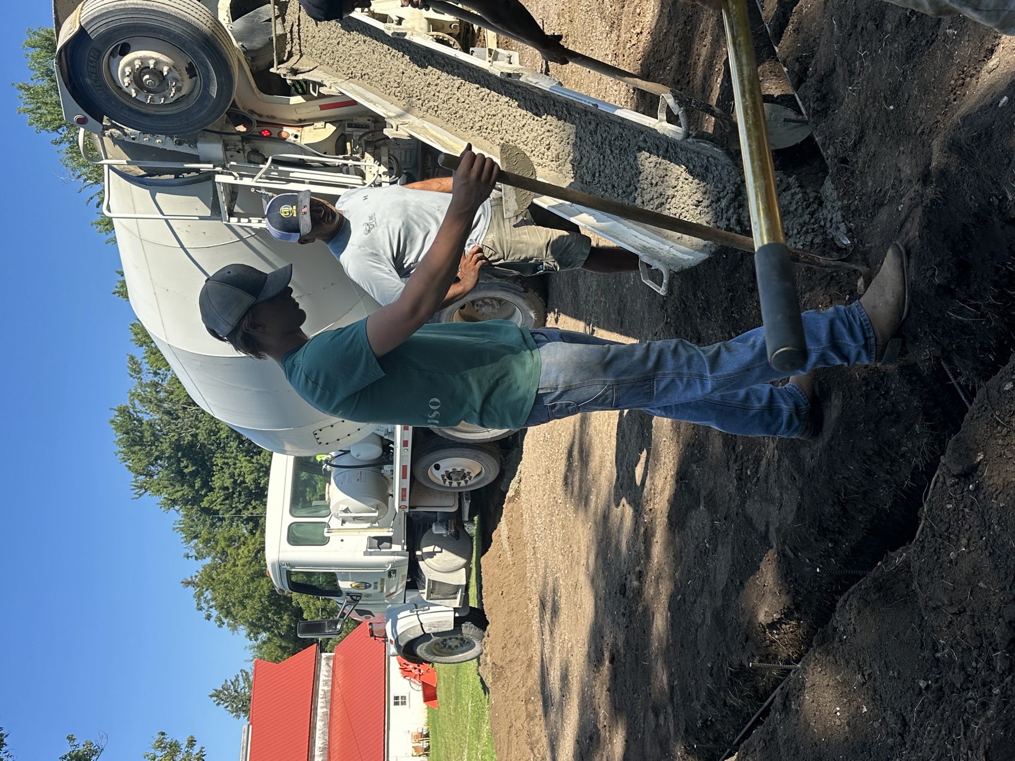 Crew guiding the chute during a concrete footing pour