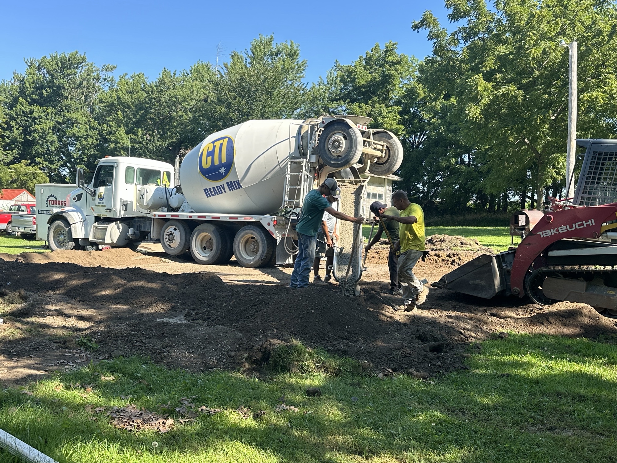 Concrete truck and skid steer during a footing pour