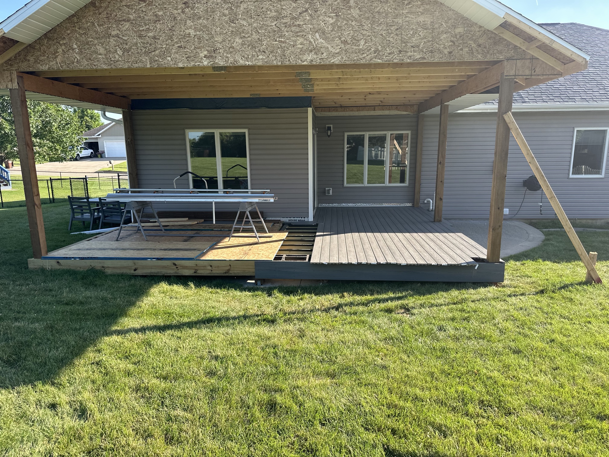 Covered deck structure framed with decking partially laid