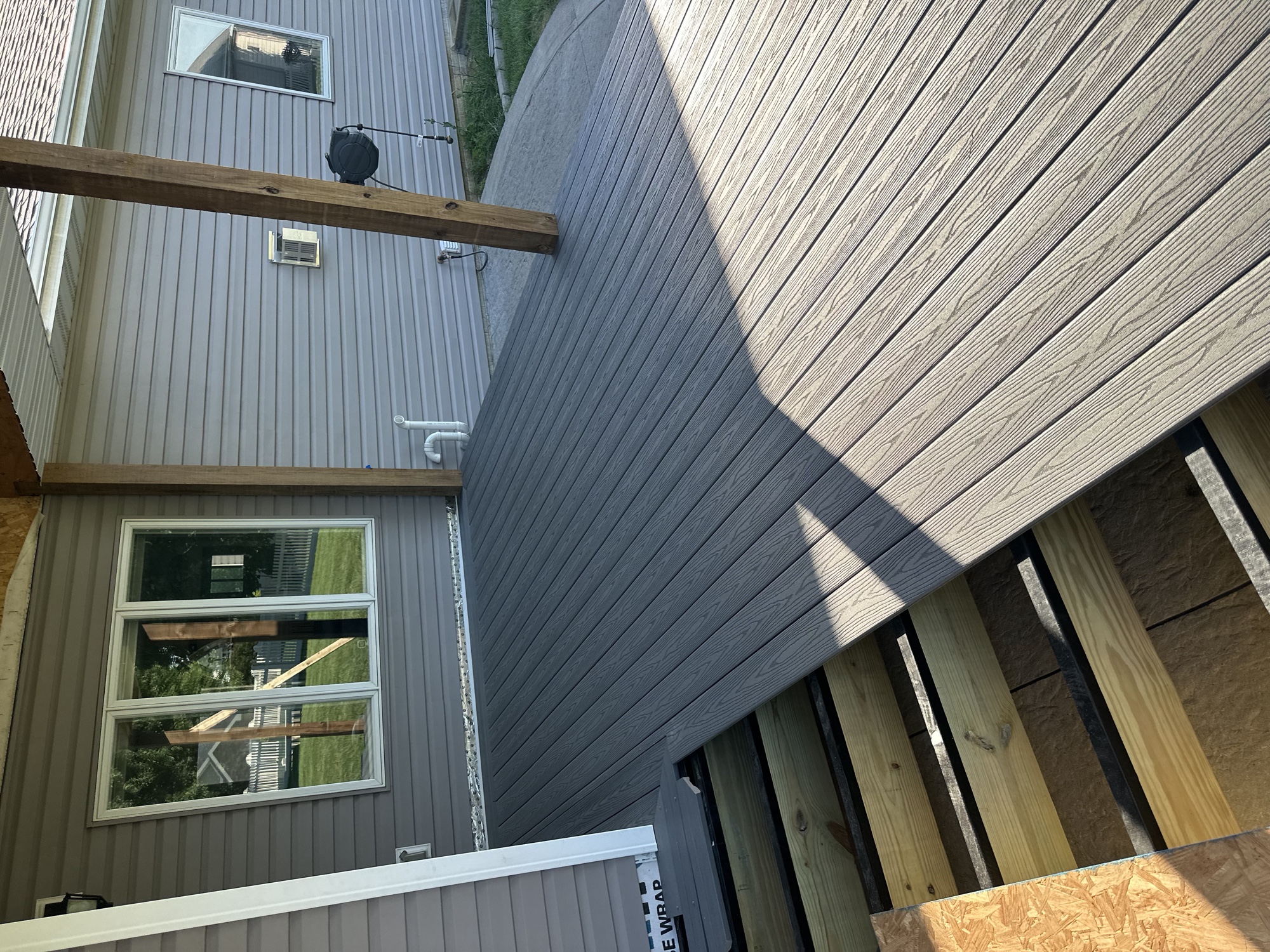 Composite decking being installed over steel joists on a covered patio