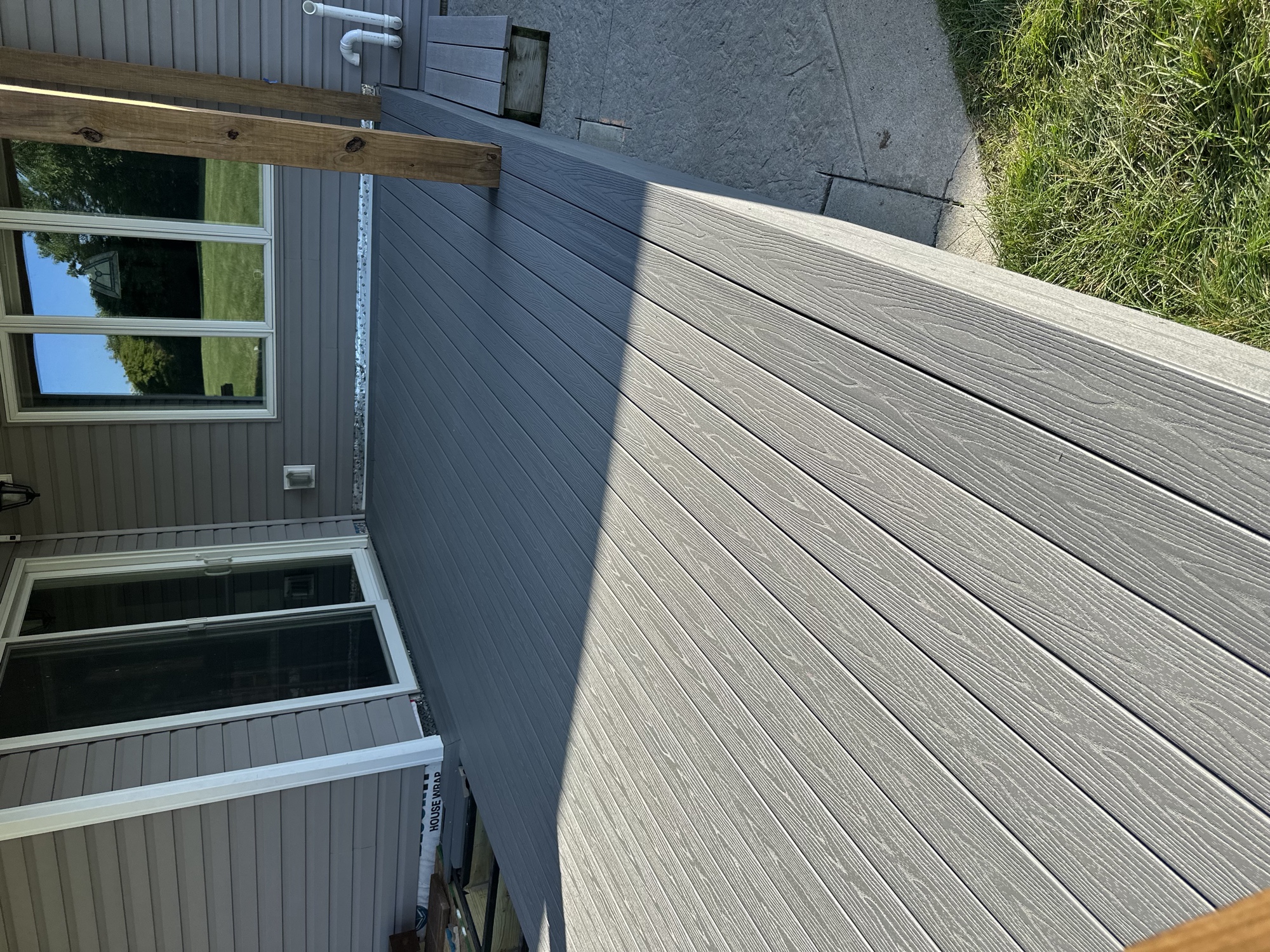 Finished two-tone composite deck boards outside a patio door