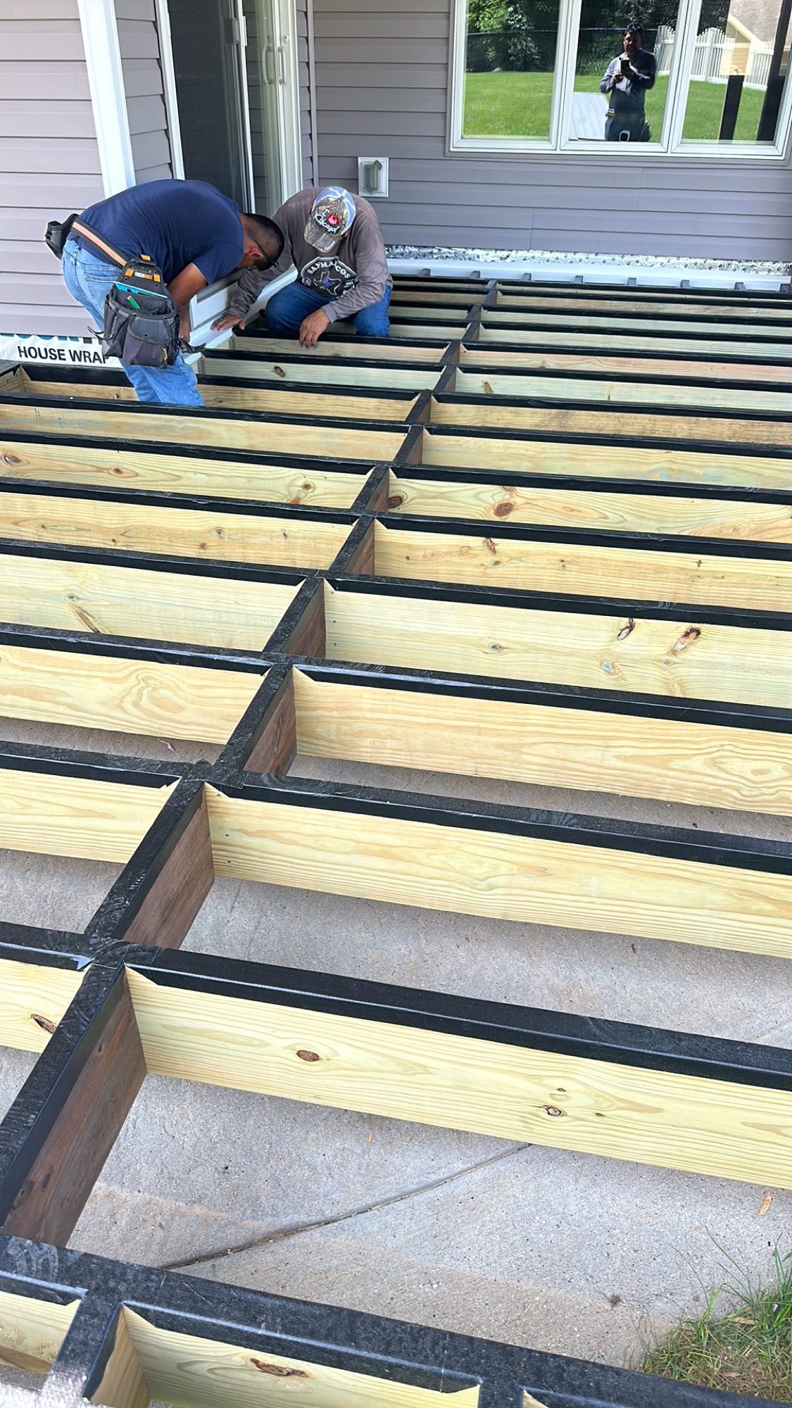 Crew installing steel-framed deck joists