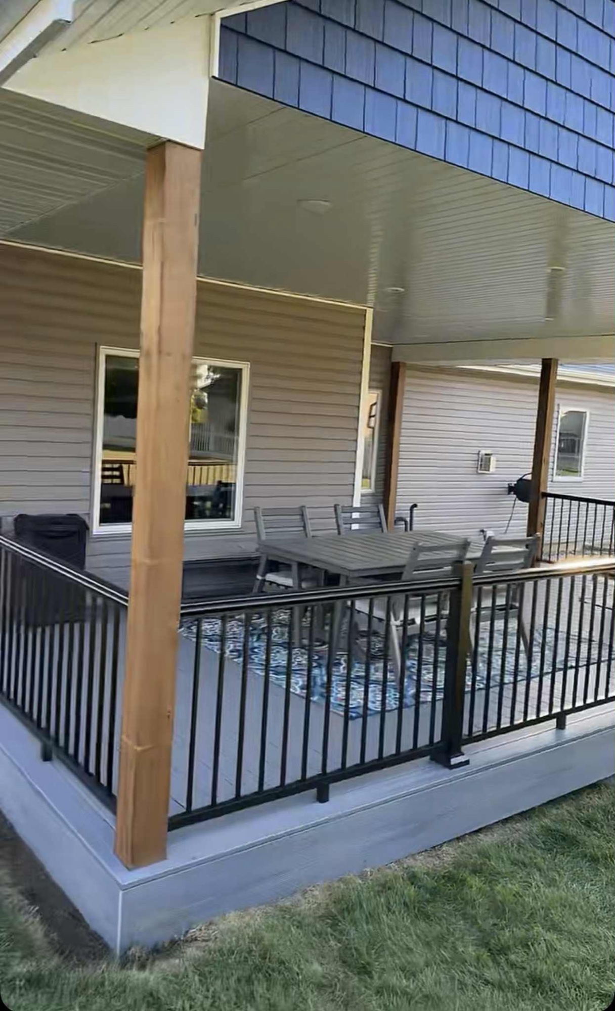 Covered porch with black aluminum railing and composite decking