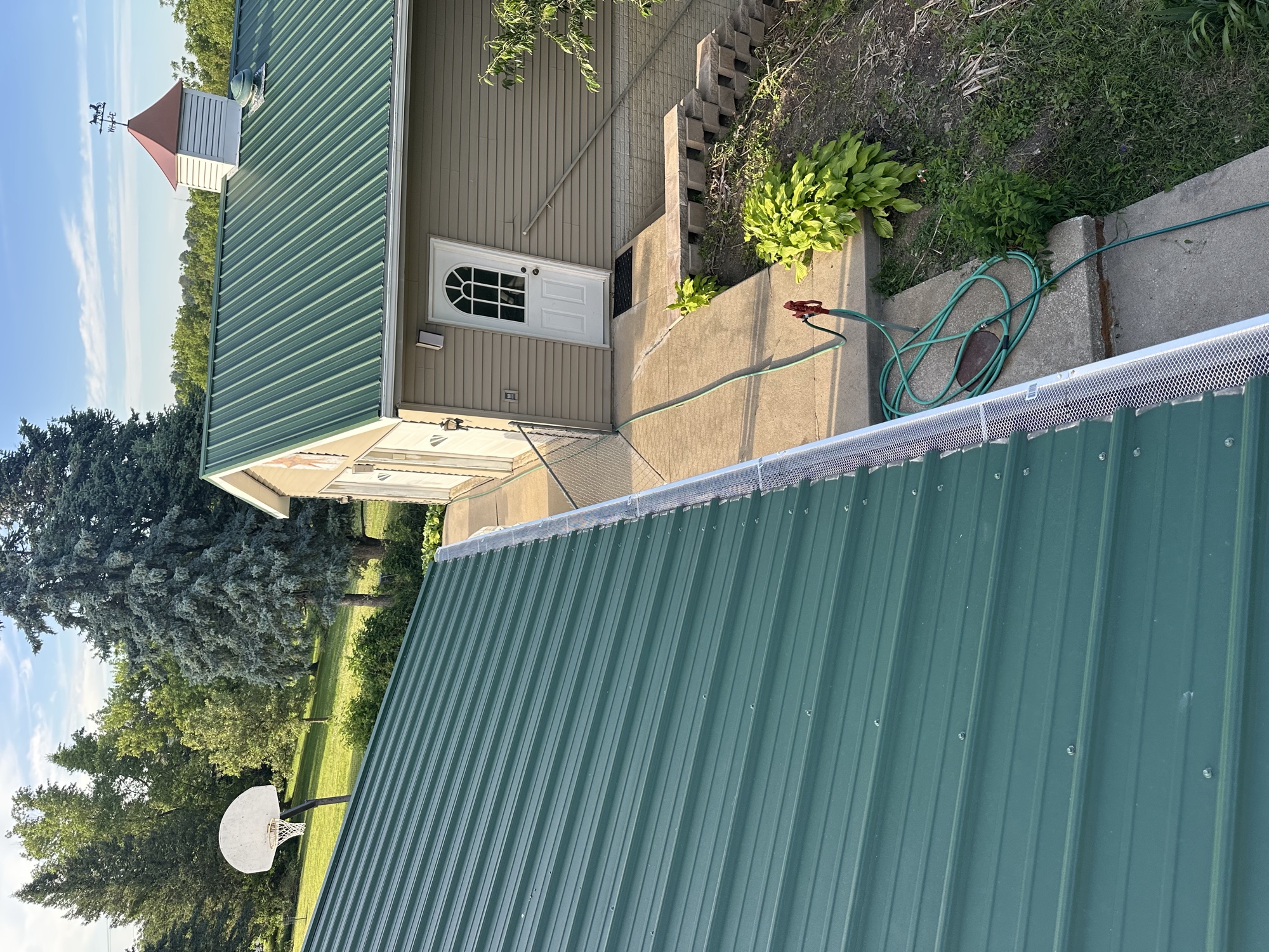 Green metal roof with new gutter guards installed