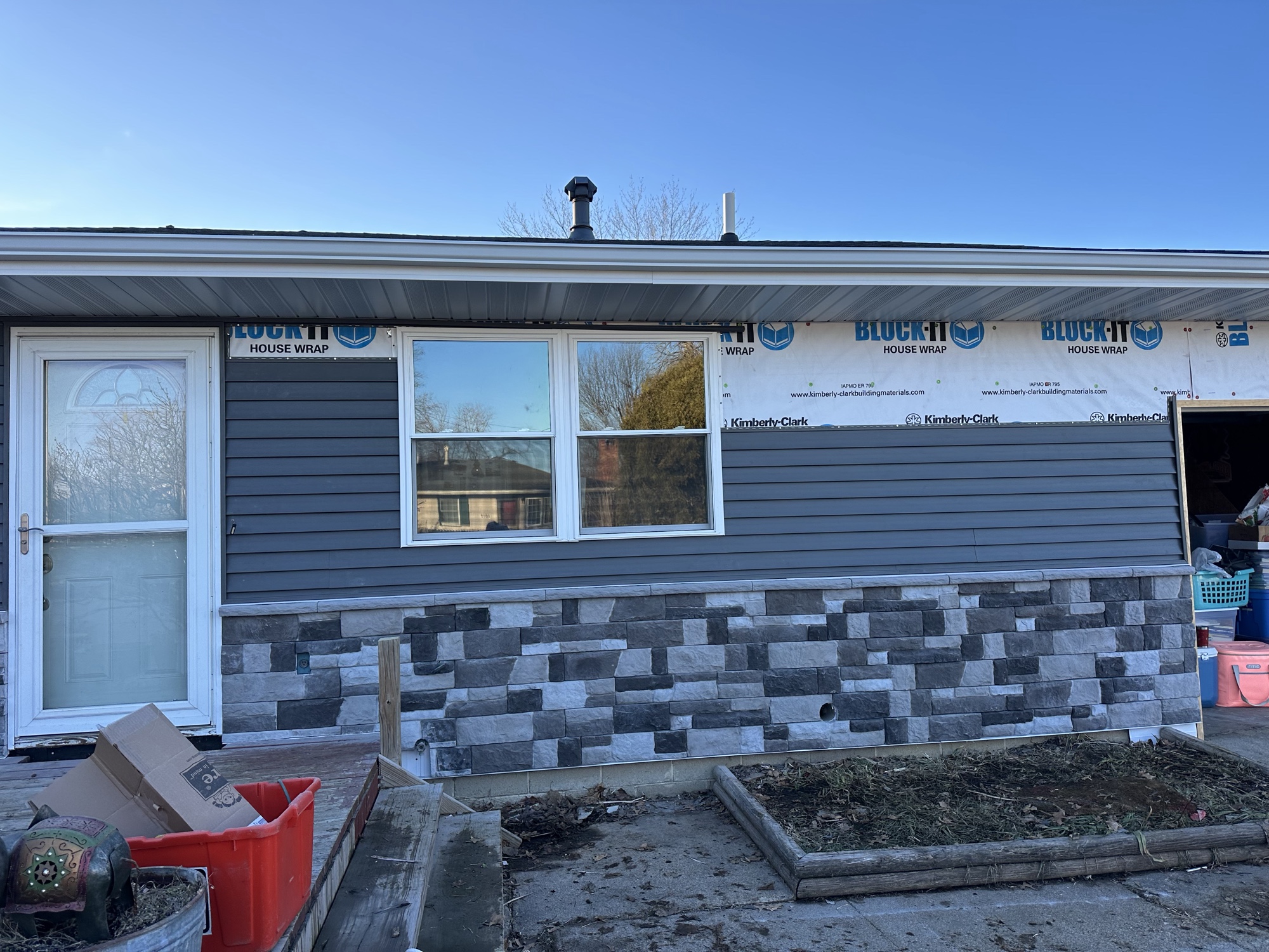 Siding install in progress over house wrap