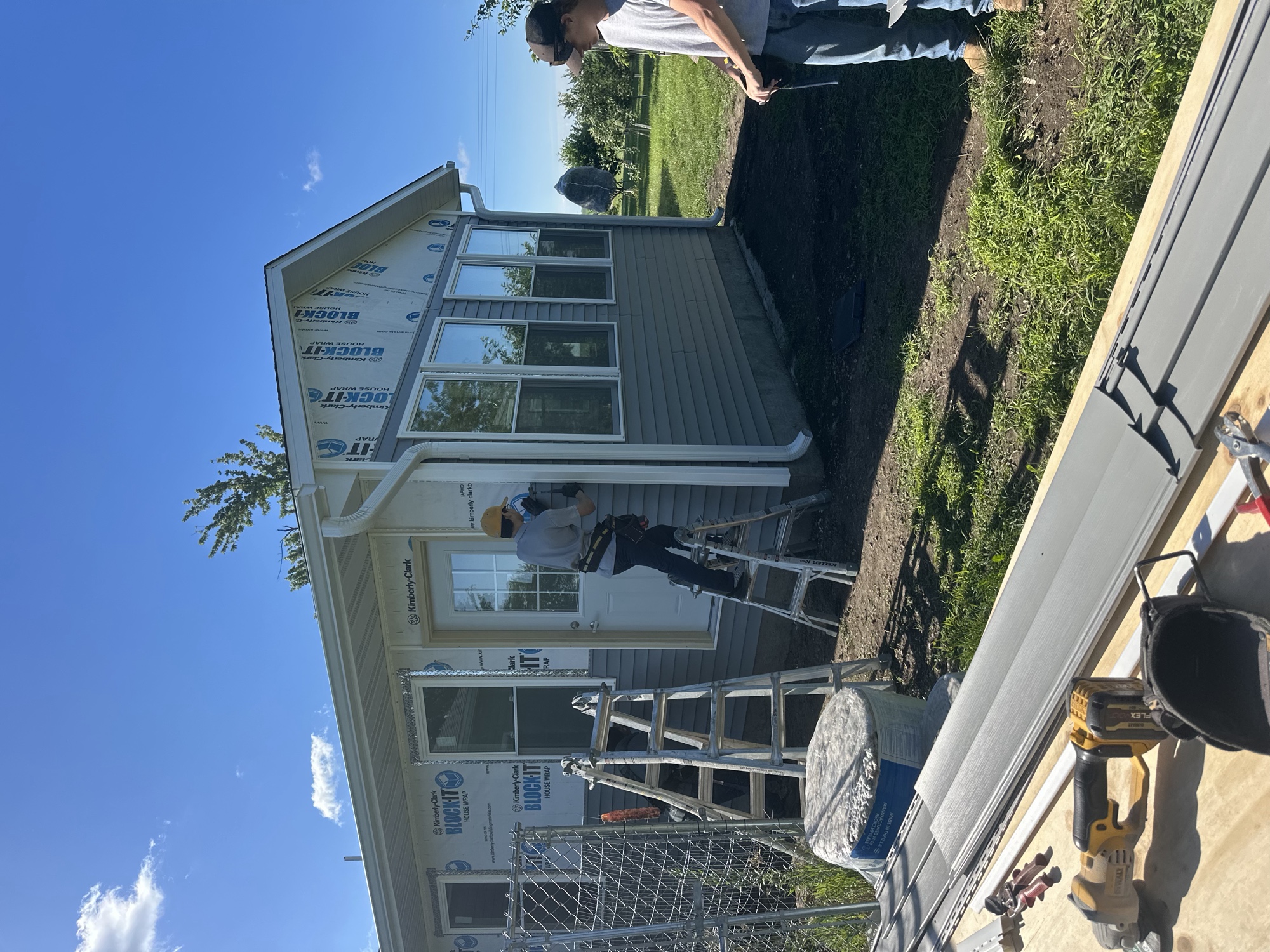 Crew siding a sunroom addition on a sunny day